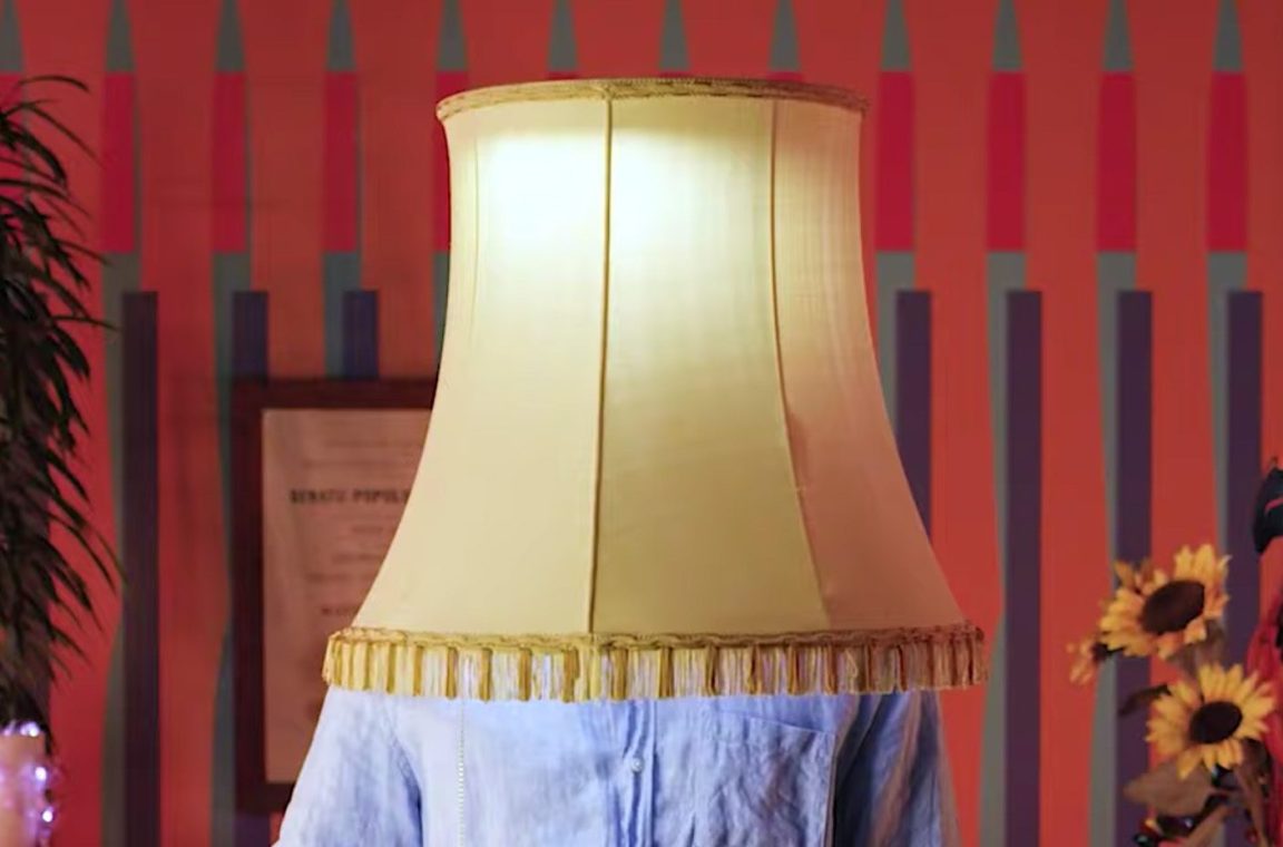 Visual aus dem Video (Mann mit Lampe auf den Schultern)